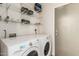 Functional laundry room featuring a white washer and dryer and wire shelving for ample storage at 6589 E Casa De Leon Ln, Gold Canyon, AZ 85118