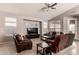 Cozy living room with ceiling fan, large windows, comfortable seating, and entertainment center at 6589 E Casa De Leon Ln, Gold Canyon, AZ 85118