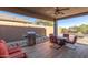 Inviting covered patio with a ceiling fan, stainless steel grill, and comfortable outdoor seating area at 6589 E Casa De Leon Ln, Gold Canyon, AZ 85118