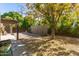 Private backyard featuring mature trees, partial patio cover, and lush landscaping at 7345 E Rovey Ave, Scottsdale, AZ 85250