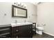 Bathroom featuring double sinks, dark wood cabinetry, and modern lighting at 7345 E Rovey Ave, Scottsdale, AZ 85250