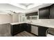 Modern kitchen with breakfast bar, stainless steel dishwasher, and a view into the main living space at 7345 E Rovey Ave, Scottsdale, AZ 85250