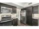 A well-equipped kitchen features stainless steel appliances and dark cabinetry, complemented by modern countertops at 7345 E Rovey Ave, Scottsdale, AZ 85250