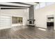 Spacious living room featuring sleek wood floors, a modern fireplace, and vaulted ceilings at 7345 E Rovey Ave, Scottsdale, AZ 85250