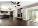 Open-concept living area with sleek dark floors, modern fireplace, and built-in shelving and adjacent kitchen at 7345 E Rovey Ave, Scottsdale, AZ 85250