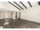 Bright living room with striking beam ceilings, wood-look floors, and a modern chandelier at 7345 E Rovey Ave, Scottsdale, AZ 85250