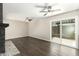 Spacious living room featuring dark wood floors, ceiling fans, fireplace, and sliding glass door to the outdoor patio at 7345 E Rovey Ave, Scottsdale, AZ 85250