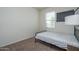 Simple bedroom with a single bed and a view from the window, offering a minimalist feel at 7734 W Florence Ave, Phoenix, AZ 85043