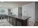 Close-up of kitchen island featuring a sink, countertop seating, and a view of the dining area at 7734 W Florence Ave, Phoenix, AZ 85043