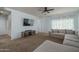 Inviting living room with plush carpeting, a ceiling fan, and a large sectional sofa for comfortable seating at 7734 W Florence Ave, Phoenix, AZ 85043