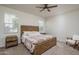 Comfortable main bedroom with a rustic wooden bed frame, bedside tables, and neutral carpeting at 7734 W Florence Ave, Phoenix, AZ 85043