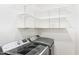 Well-organized laundry area featuring modern washer and dryer units, complemented by wall shelving at 7920 E Via Camello -- # 49, Scottsdale, AZ 85258