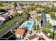 Aerial view of community pool with palm trees and nearby houses at 7920 E Via Camello -- # 49, Scottsdale, AZ 85258