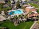 Aerial view of a community pool surrounded by palm trees and lush landscaping at 7920 E Via Camello -- # 49, Scottsdale, AZ 85258