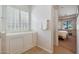 Bright bathroom with a walk-in tub, white walls, and shuttered windows at 800 W Palo Brea Dr, Litchfield Park, AZ 85340