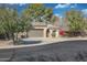 Inviting home exterior featuring a well-maintained lawn, mature trees, and a two-car garage at 800 W Palo Brea Dr, Litchfield Park, AZ 85340