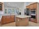 Open kitchen with stainless steel appliances, island, and a view into the living room at 800 W Palo Brea Dr, Litchfield Park, AZ 85340