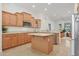 Bright kitchen featuring an island, modern appliances, and wooden cabinetry at 800 W Palo Brea Dr, Litchfield Park, AZ 85340