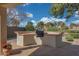 An outdoor kitchen with a built-in grill and ample counter space for entertaining in covered patio area at 800 W Palo Brea Dr, Litchfield Park, AZ 85340