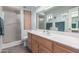 Well-lit bathroom featuring a vanity with a sink, a large mirror, and a glass-enclosed shower at 8012 E Monte Ave, Mesa, AZ 85209