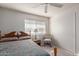 Comfortable bedroom with a ceiling fan, natural light, and a classic wooden bed frame with a floral quilt at 8012 E Monte Ave, Mesa, AZ 85209