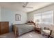 Comfortable bedroom with a ceiling fan, natural light, and a classic wooden bed frame with a floral quilt at 8012 E Monte Ave, Mesa, AZ 85209