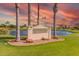 Sunland Village East Golf Club sign surrounded by manicured lawns and palm trees under a colorful sunset sky at 8012 E Monte Ave, Mesa, AZ 85209