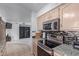 Modern kitchen with stainless steel appliances, granite countertops, and a tile backsplash at 8012 E Monte Ave, Mesa, AZ 85209