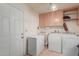 Functional laundry room with a washer, dryer, sink, freezer, and cabinetry for storage and organization at 8012 E Monte Ave, Mesa, AZ 85209