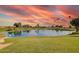 Scenic view of a lush pond surrounded by green grass, trees, and palm trees; a serene outdoor space at 8012 E Monte Ave, Mesa, AZ 85209