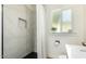 Bathroom featuring a walk-in shower with tile surround, modern fixtures, and a window for natural light at 809 N 11Th Ave, Phoenix, AZ 85007