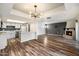 Open concept living room featuring a fireplace, modern light fixture, and wood-look flooring at 8344 N 21St Dr # I105, Phoenix, AZ 85021