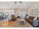 Open-concept living room features a stone fireplace, hardwood floors, and plenty of natural light at 8499 E Jumping Cholla Dr, Gold Canyon, AZ 85118