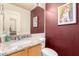 Half-bathroom with granite countertops, patterned walls, and decorative lighting at 911 W Sandra Ter, Phoenix, AZ 85023