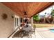 Stylish covered patio with wood ceiling, fan, dining area, and a view of the lush backyard at 911 W Sandra Ter, Phoenix, AZ 85023