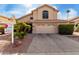 Tan two-story home with a two car garage, tile roof, well-maintained lawn, and desert landscaping at 911 W Sandra Ter, Phoenix, AZ 85023