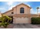 Tan two-story home with a two car garage, tile roof, and desert landscaping at 911 W Sandra Ter, Phoenix, AZ 85023