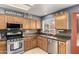 Traditional kitchen with stainless steel appliances, wood cabinets, and mosaic backsplash at 911 W Sandra Ter, Phoenix, AZ 85023