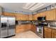 Spacious kitchen featuring stainless steel appliances, wood cabinets, and tile flooring at 911 W Sandra Ter, Phoenix, AZ 85023