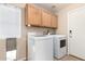 Laundry room with washer, dryer, cabinets, and a doggie door at 911 W Sandra Ter, Phoenix, AZ 85023