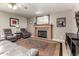 Cozy living room with a fireplace, plush seating, a ceiling fan, and neutral tones at 911 W Sandra Ter, Phoenix, AZ 85023