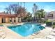 Sparkling community pool with ample lounge chairs for relaxation in a tropical setting at 9270 E Mission Ln # 211, Scottsdale, AZ 85258