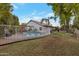 Wide backyard view featuring a fenced pool, covered patio, and a lush lawn, perfect for outdoor activities at 928 S San Joaquin Ct, Gilbert, AZ 85296