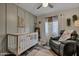 Cozy baby room with a crib, accent wall, and ceiling fan at 928 S San Joaquin Ct, Gilbert, AZ 85296