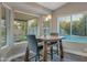 Bright breakfast nook with a wooden table, wicker chairs, and large windows overlooking the pool at 928 S San Joaquin Ct, Gilbert, AZ 85296