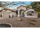 Charming single-story home featuring a welcoming arched entryway, well-manicured landscaping, and a two car garage at 928 S San Joaquin Ct, Gilbert, AZ 85296