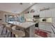 A well-lit kitchen features a breakfast bar with seating, white cabinets, and stainless steel appliances at 928 S San Joaquin Ct, Gilbert, AZ 85296