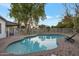 Inviting backyard pool with lounge chairs, surrounded by a brick patio and lush landscaping, perfect for relaxation at 928 S San Joaquin Ct, Gilbert, AZ 85296