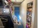 Well-organized laundry room with shelving, storage, washer and dryer hookups, and a brightly painted blue door at 94 W 12Th St, Florence, AZ 85132