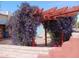 A red pergola covered in purple flowers in an enclosed yard at 94 W 12Th St, Florence, AZ 85132